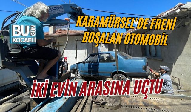 KARAMÜRSEL'DE FRENİ BOŞALAN OTOMOBİL İKİ EVİN ARASINA UÇTU