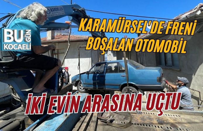 KARAMÜRSEL'DE FRENİ BOŞALAN OTOMOBİL İKİ EVİN ARASINA UÇTU